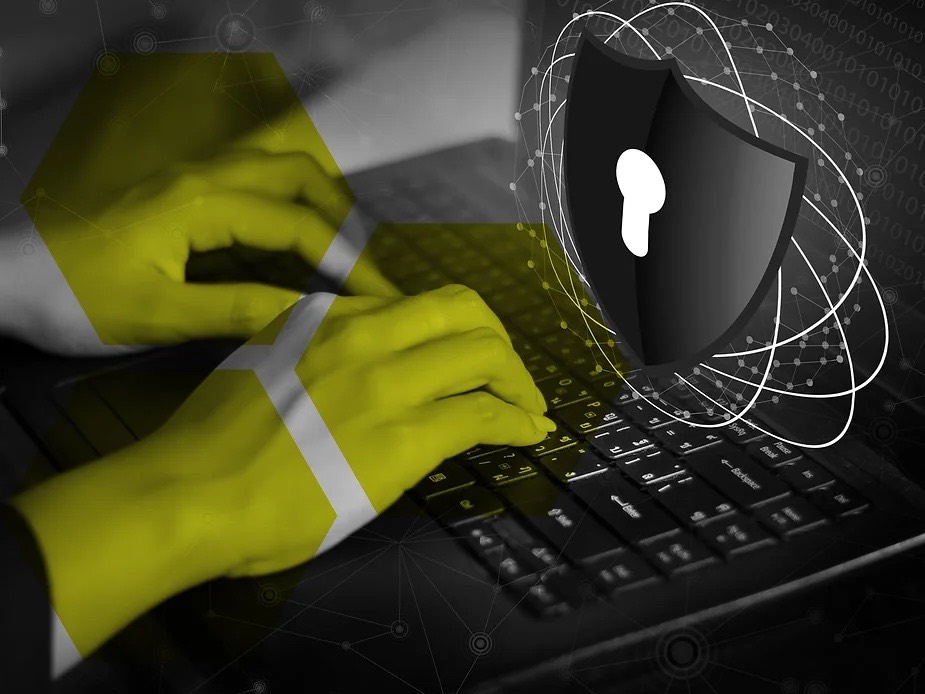 Hände auf einer Laptop-Tastatur mit digitalem Schutzschild – Cybersecurity